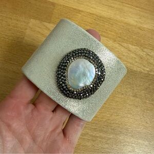 Wide band rigid slide on bracelet with large statement faux stone